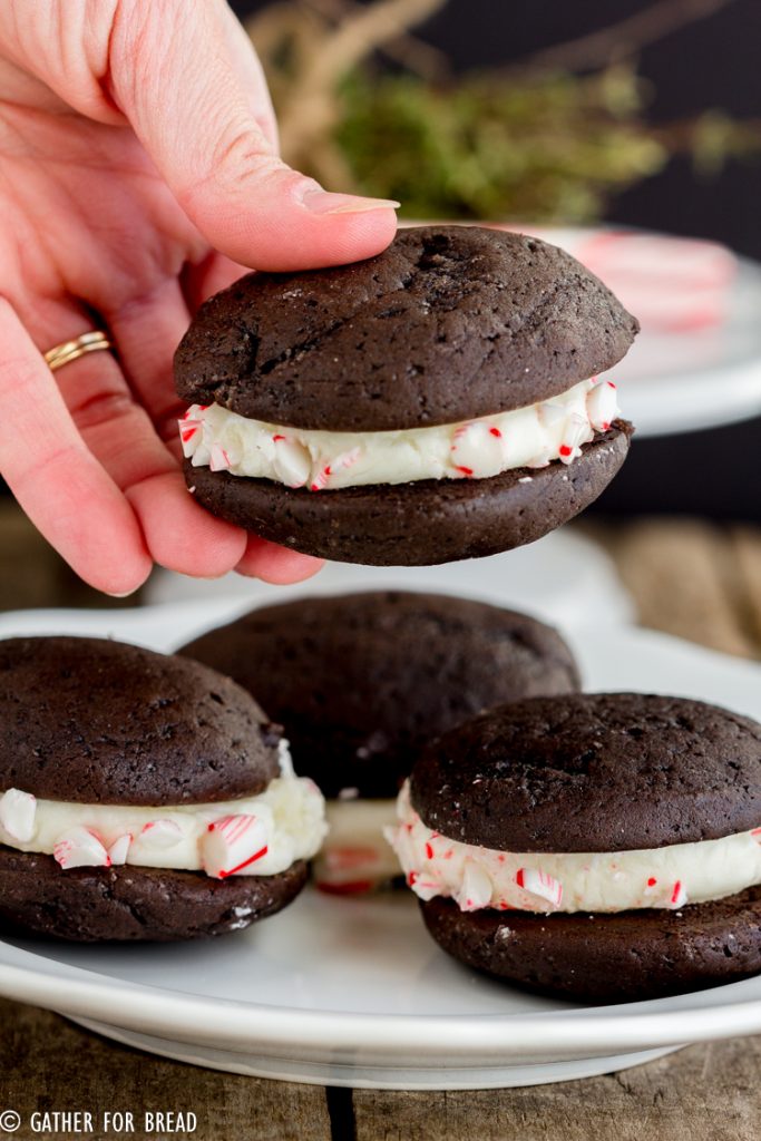 Chocolate Whoopie Pies with Peppermint Whipped Filling - Delicious Christmas inspired chocolate sandwich cookies filled with a whipped peppermint filling and rolled in crushed peppermint candy canes Perfect dessert to serve for the holidays.