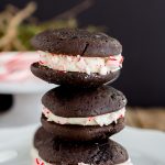 Chocolate Whoopie Pies with Peppermint Whipped Filling - Delicious Christmas inspired chocolate sandwich cookies filled with a whipped peppermint filling and rolled in crushed peppermint candy canes Perfect dessert to serve for the holidays.