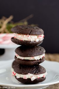Chocolate Whoopie Pies with Peppermint Whipped Filling - Delicious Christmas inspired chocolate sandwich cookies filled with a whipped peppermint filling and rolled in crushed peppermint candy canes Perfect dessert to serve for the holidays.