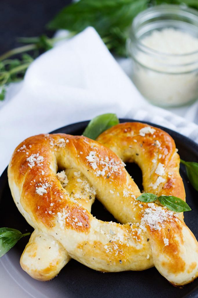 Garlic Parmesan Soft Pretzels - Fresh soft pretzels mixed with herbs and Parmesan cheese for a tasty treat any time. These pretzels mimic Auntie Anne's and are the perfect savory snack.