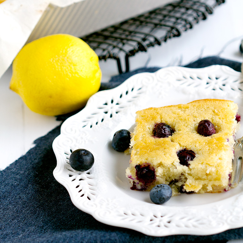 Lemon Blueberry Snack Cake - Simple cake in a pan with fresh blueberries and lemon for zest. Delightful! | gatherforbread.com