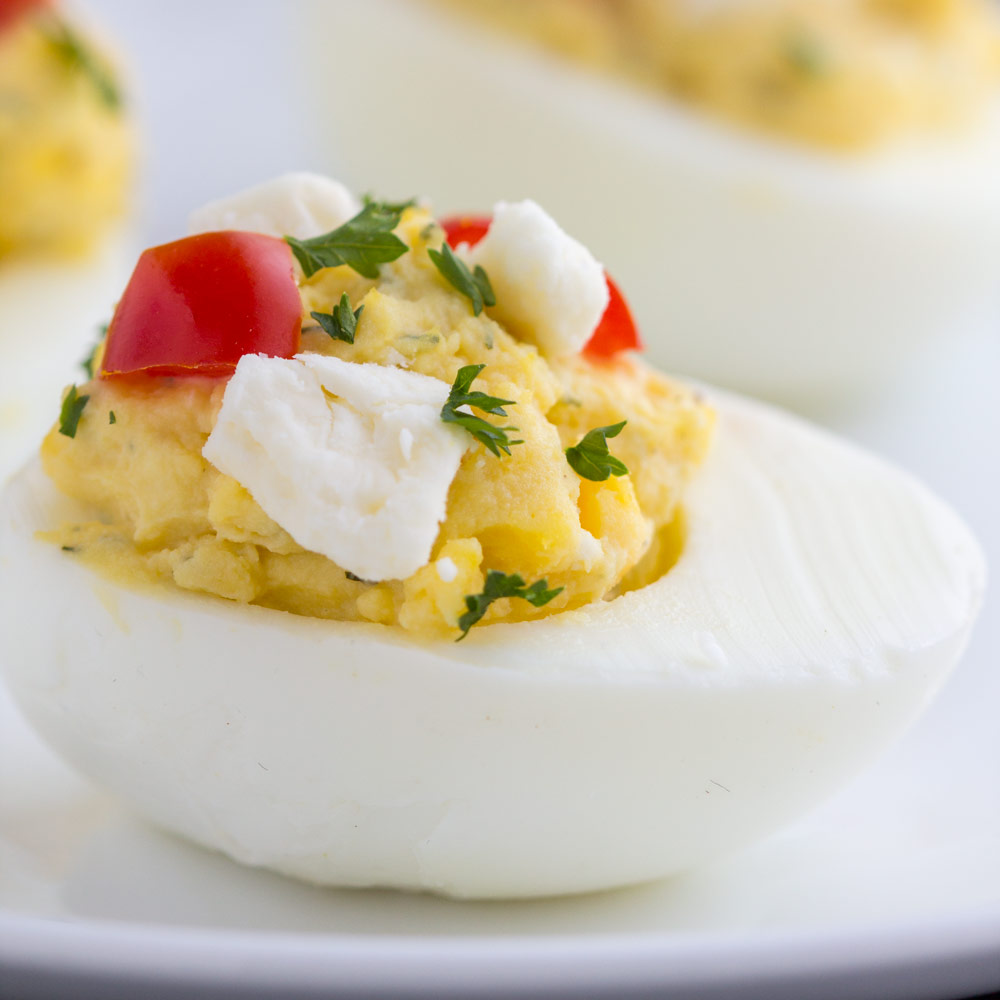 Feta Deviled Eggs - Healthier deviled eggs made with Greek yogurt, Feta cheese and dill for a savory appetizer that's ready in minutes. These Greek style eggs with herbs are delicious!