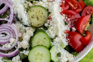 Easy Mediterranean Salad - Easy Greek style salad with homemade dressing recipe. Topped with tomato, cucumber, romaine and Feta. Light on calories for your diet. Gluten free.