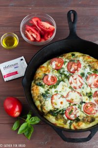 Skillet Pizza with Pesto Tomatoes and Spinach - Homemade pizza pie dough made in cast iron skillet with fresh pesto, tomato, and spinach toppings. Ready for Friday pizza night with these garden-fresh ingredients.