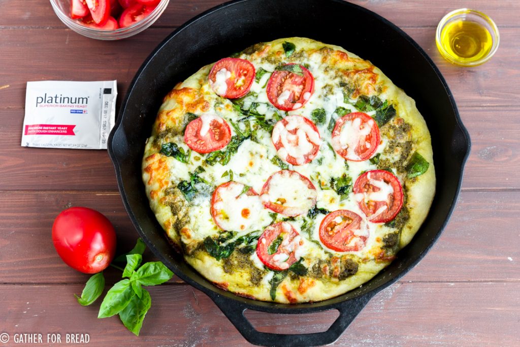Skillet Pizza with Pesto Tomatoes and Spinach - Homemade pizza pie dough made in cast iron skillet with fresh pesto, tomato, and spinach toppings. Ready for Friday pizza night with these garden-fresh ingredients.